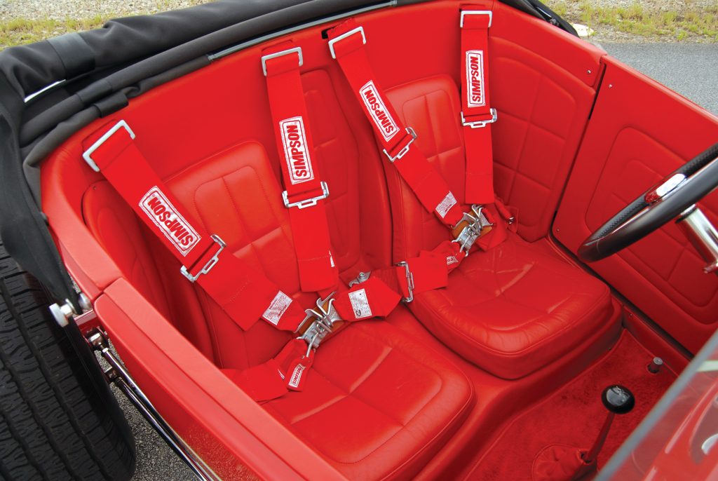 Red leather covers the custom bucket seats, and Simpson race  harnesses keep the occupants firmly in place.